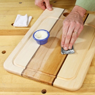 Spreading paste wax finish on a wood cutting board