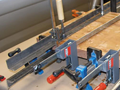 Aiding in panel clamping by using caul made with angle iron