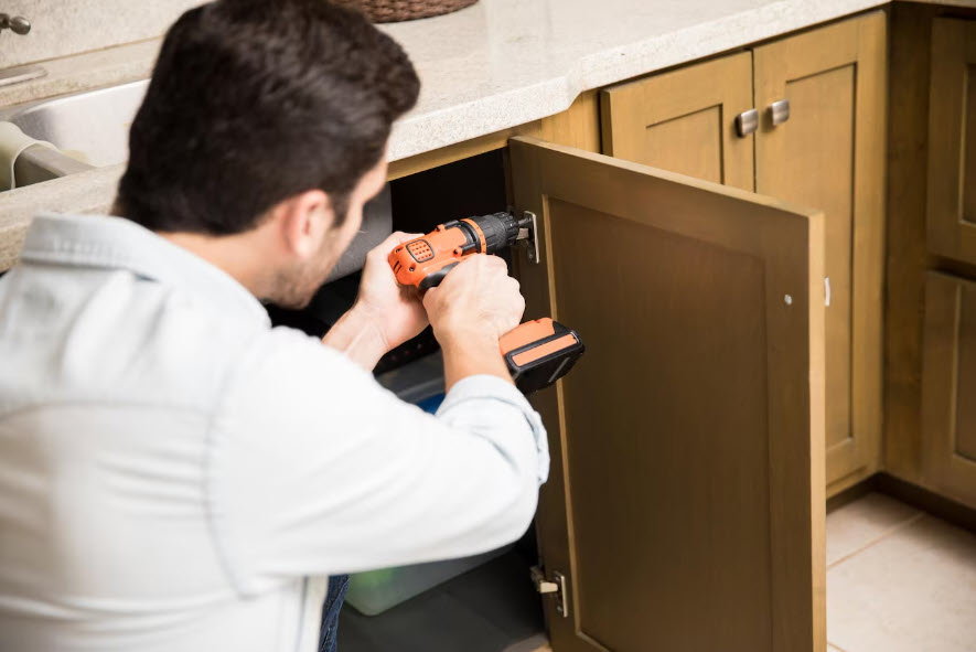 man changing out kitchen cabinet hardware