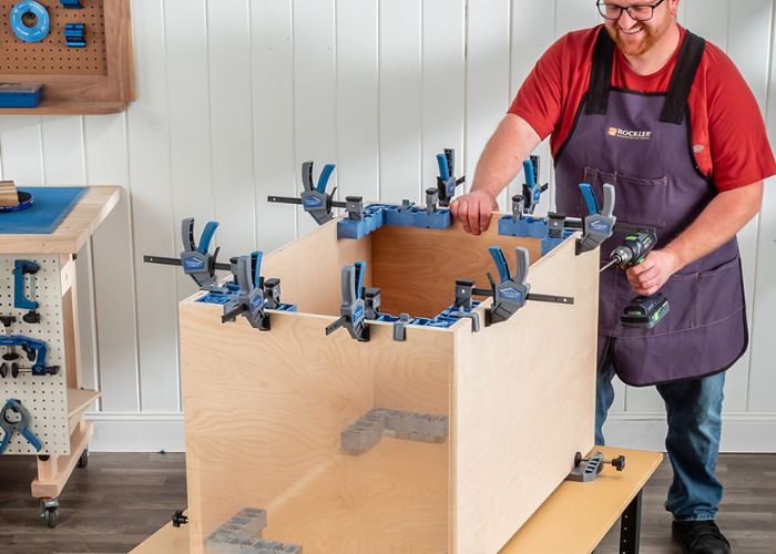 man using clamp-it corner jigs to clamp box
