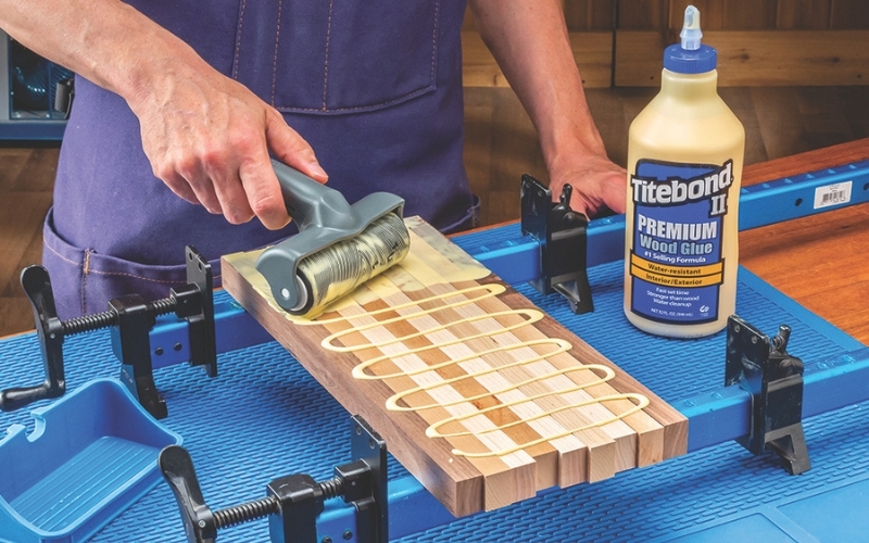 man rolling wood glue with roller