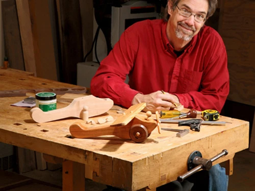 Rob Johnstone displaying the parts for and completed toy airplane project