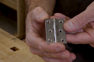 person holding butt hinge