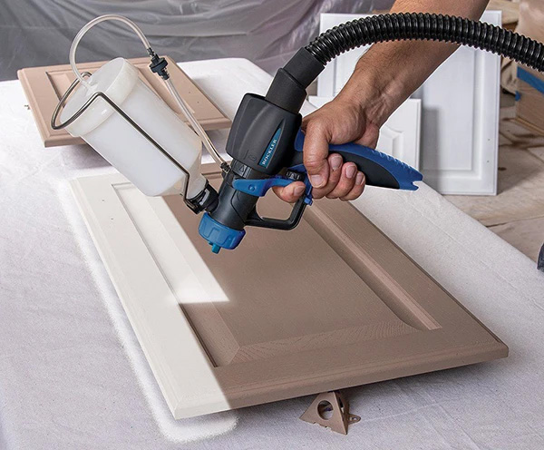 Applying paint to cabinet door with hvlp spray gun