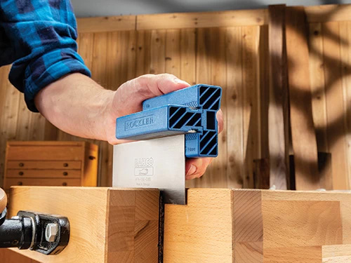 Running sharpener over edge of cabinet scraper