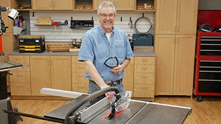 man standing next to table saw