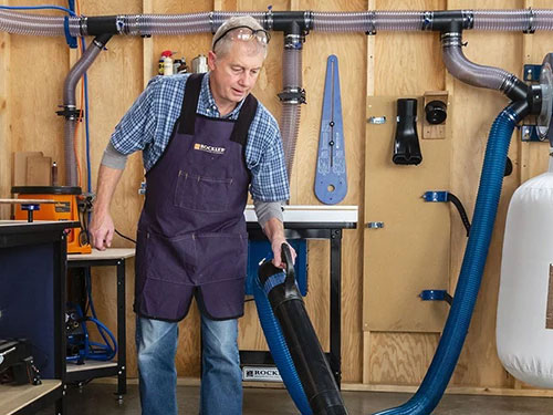 Woodworker sweeping workshop dust