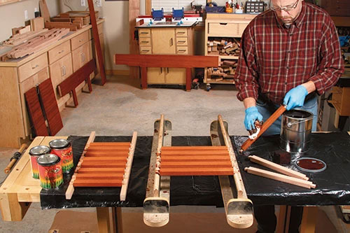 Wiping a warm brown stain on slats