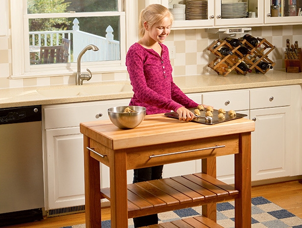 girl making cookies behind kitchen island