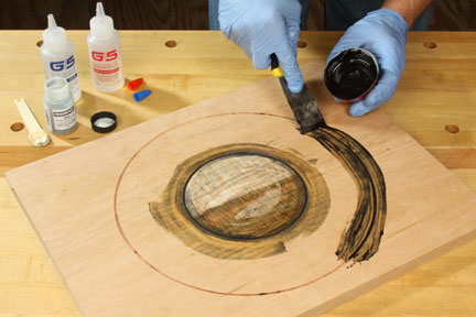 Spreading a mixed black epoxy inlay around center piece of lazy susan
