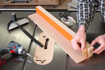Attaching sandpaper strip to fence with double-sided tape