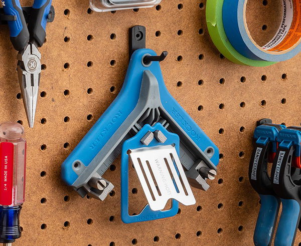 branding iron alignment jig hangs on pegboard