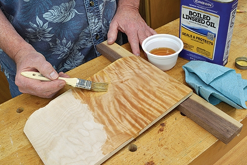 Brushing boiled linseed oil on maple wood