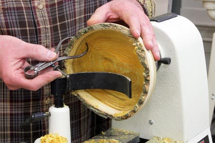 Using a calipers to check the interior thickness of a natural edge bowl blank