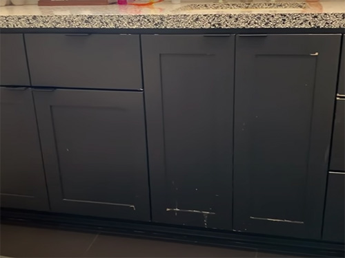 Bathroom vanity with chipped paint and scuff marks