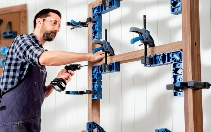 man using clamp it to work on project