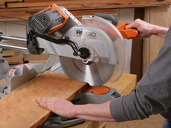 Pushing a sliding miter saw cut through a board