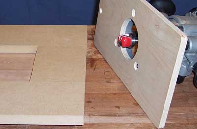 Router attached to a plywood template to guide router cut