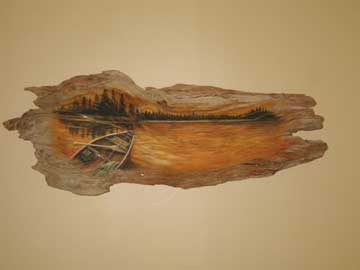 A piece of driftwood with a river canoeing scene painted on it