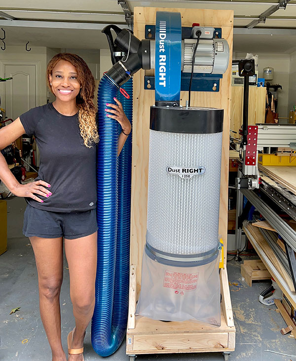 Char Miller-King standing next to dust collector