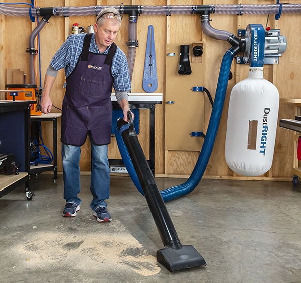 woodworker sweeping workshop dust