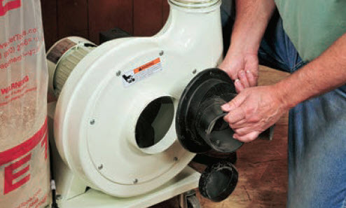 man opening ductwork of dust collector
