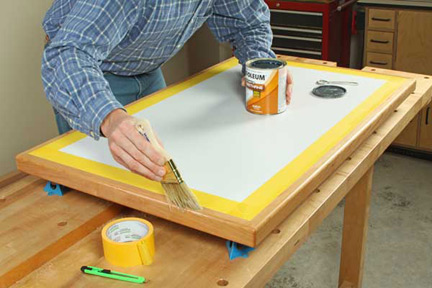 Brushing polyurethane on edging of worktable