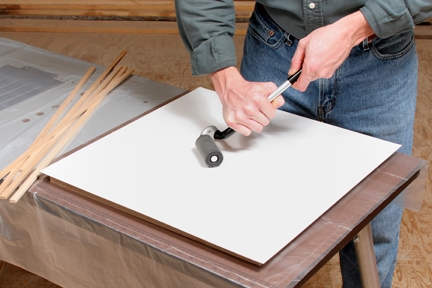 Using j-roller to flatten an even out adhesive under plastic laminate