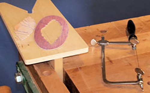 Fret saw for cutting veneer laying on a benchtop