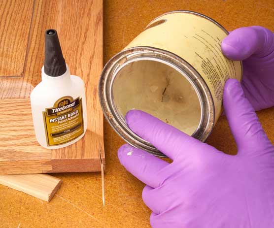 Scooping paste wax with a gloved finger