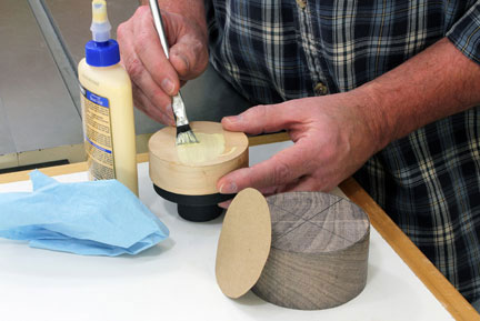 Spreading glue to add paper layer to glue block