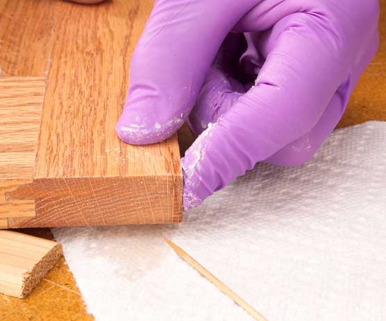 Using finger to hold glued wood crack closed
