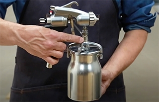 man holding an HVLP spray gun