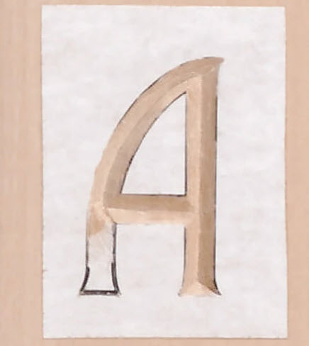 Letter A partially carved from a template