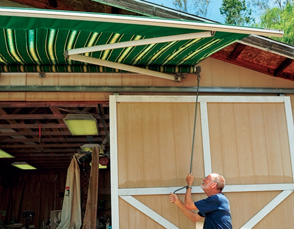 Setting up large awning over workshop door
