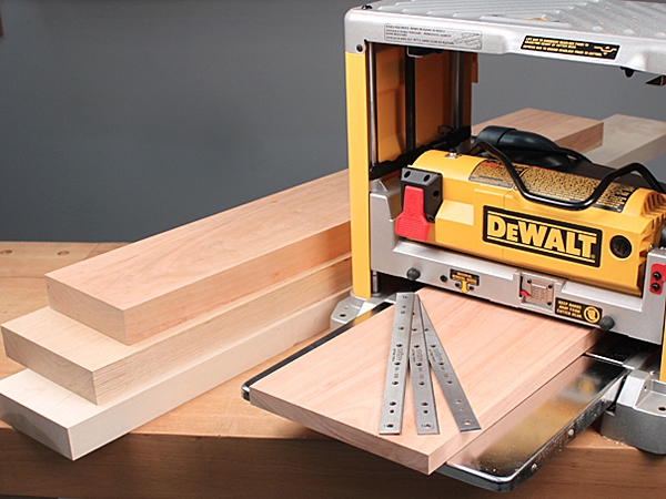 A portable planer with planed lumber and extra blades