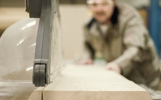 man doing rip cut on table saw