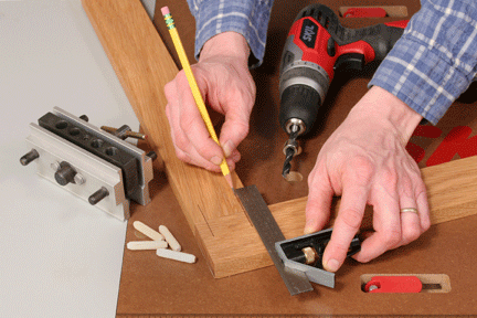 Using a pencil to draw the installation points for dowels