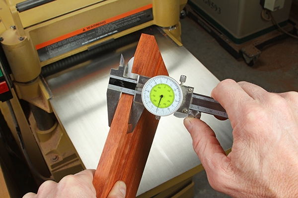 Using a caliper to check the thickness of stock for cutting dowels
