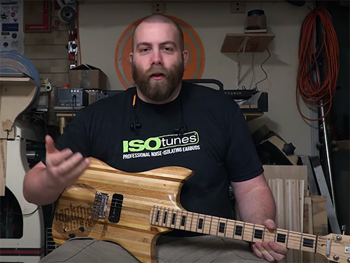 Paul Jackman with a guitar made from recycled pallet wood