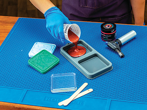 Pouring red colored epoxy into coaster mold