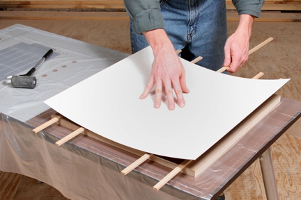 Pressing laminate sheet over panel