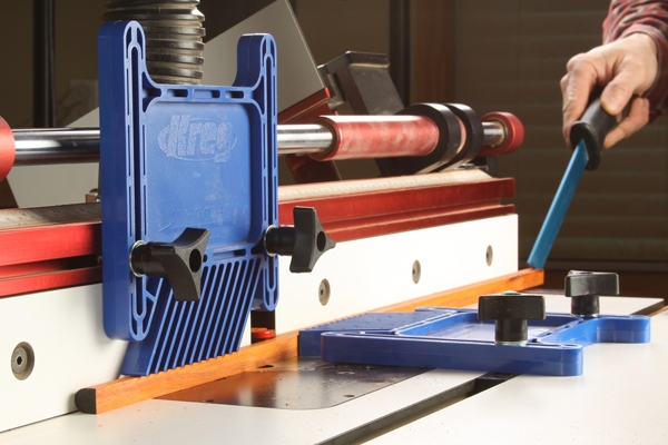 Using push stick and featherboards to guide dowel cut through router