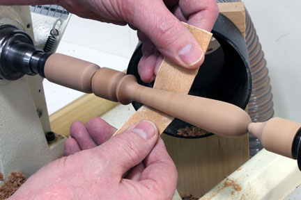 Sanding down spindle at a lathe