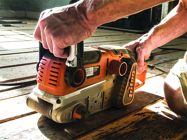Triton belt sander sanding down lumber