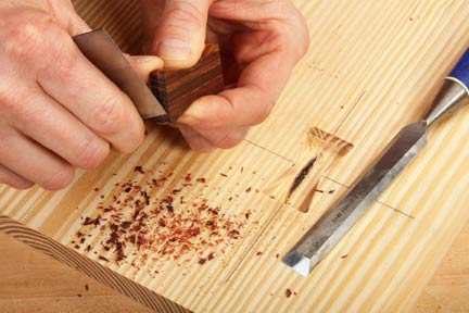 Cutting down butterfly inlay insert edges with scraper