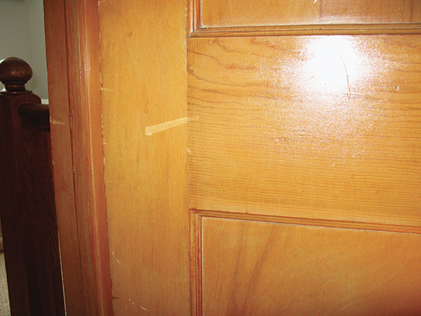 Close-up of a scratch in lacquer finish on door