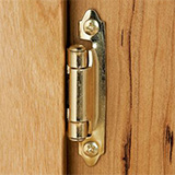 Semi-concealed hinge installed in a cabinet