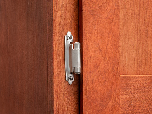 Cabinet door with installed semi-concealed hinge