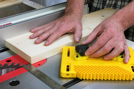 Setting featherboard on table saw before cut
